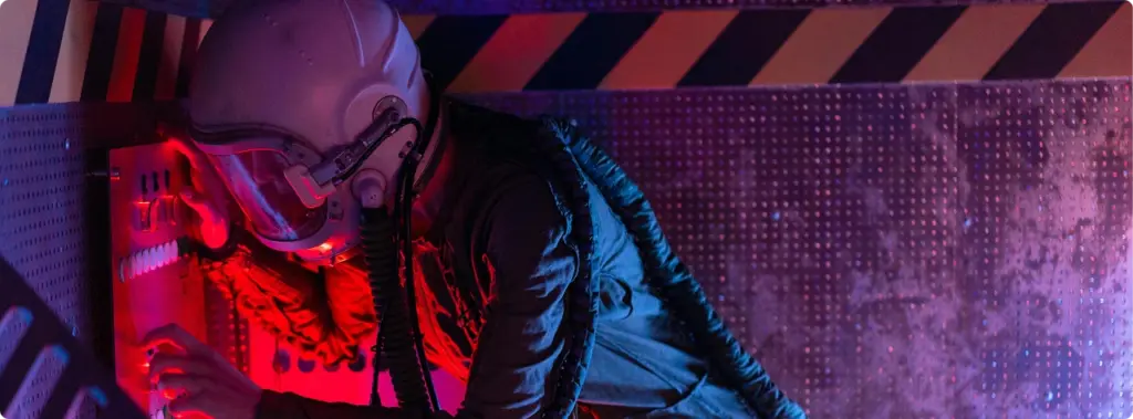 Een man in een ruimtepak stelt het bedieningspaneel in een bunker of een compartiment van het ruimteschip af onder rood-blauwe neonverlichting.